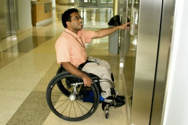 Usuario de silla de ruedas llamando a los ascensores de Mataró Park